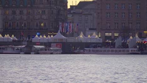 Panning-view-of-the-Christmas-market-at-Binnenalster-at-dusk-in-Hamburg,-Germany,-in-Dec-2019