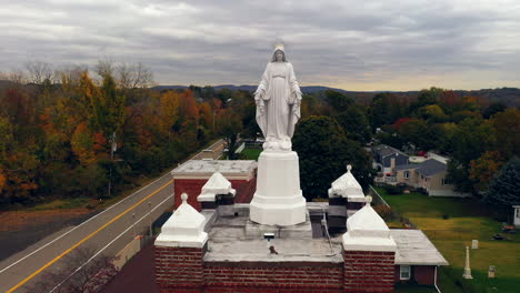 An-aerial-view-of-a-statue-of-the-Virgin-Mary-on-top-of-a-Catholic-Church-in-upstate,-NY