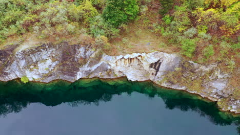 A-top-down-view-over-a-quarry-filled-with-green-water