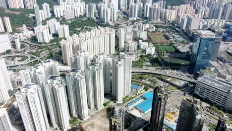 área-Urbana-De-Kowloon-En-El-Centro-De-Hong-Kong,-Vista-Aérea-De-ángulo-Bajo-Con-Tráfico-Y-Rascacielos-De-La-Ciudad