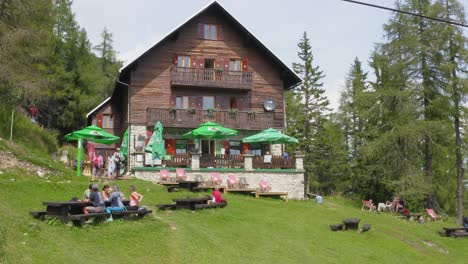 Besucher-Sitzen-Vor-Der-Dom-Na-Peci-Berghütte-In-Koroska,-Mt