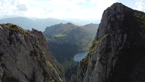 Mit-Der-Drohne-Zwischen-Zwei-Felsen-Zu-Einem-Wunderschönen-Schweizer-Bergsee-Fliegen