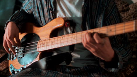 Man-plays-the-bass-guitar-while-shifting-focus
