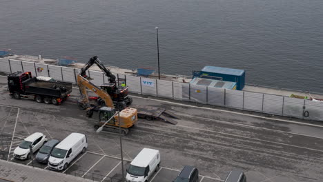 Special-machinery-for-road-constructions-being-loaded-onto-a-truck-on-a-harbor-parking-lot