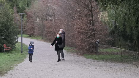 Grandparents-with-Grandchild-While-Wearing-a-Medical-Masks-Enjoying-at-Park-During-Winter
