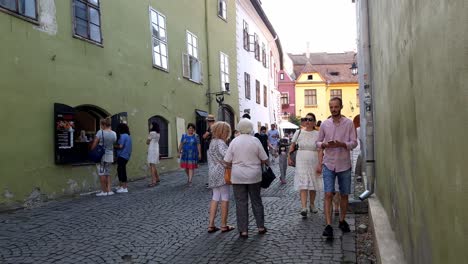 Family-And-Friends-Walking-On-The-Pavement-At-The-Historic-Center-Of-Sighisoara,-Romania-During-Covid-19-Pandemic,-static-shot