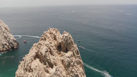 Aerial-View-of-Rock-Formation-and-Boats-in-Ocean