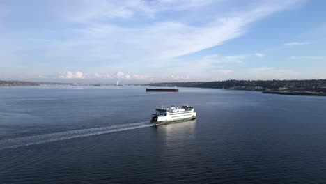 A-cloud-covered-Mount-Rainier-in-the-background-as-a-Washington-Ferry-crosses-Puget-Sound,-aerial-orbit