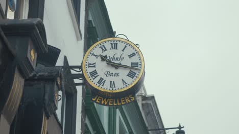 Mechanical-clock-work-clock-mounted-on-exterior-of-jewellers-shop-in-street