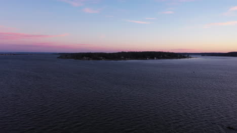 Eine-Luftaufnahme-über-Einer-Bucht,-Die-Während-Eines-Wunderschönen-Sonnenaufgangs-Auf-Eine-Insel-Gerichtet-Ist