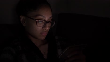 Young-UK-Asian-Female-Wearing-Glasses-Browsing-Mobile-At-Night
