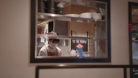 Japanische-Frau-In-Maske,-Die-In-Der-Restaurantküche-Arbeitet