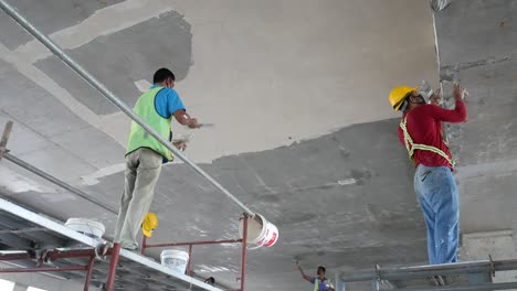 Bauarbeiter-Führen-Auf-Der-Baustelle-Deckenuntersichtsspachtelarbeiten-Durch