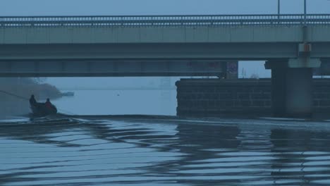 Fisherman's-driving-with-boat-in-the-Liepaja-Trade-canal-under-the-bridge-in-foggy-afternoon