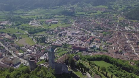 Aerial-panoramic-view-of-Borgo-Valsugana-in-Trentino-Italy-with-views-of-the-city-and-mountains,-drone-flying-backwards