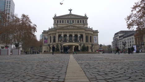 Low-angle:-Multiple-people-walking-around-the-opernplatz-in-front-of-the-Alte-Oper-in-Frankfurt