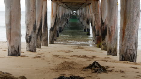 Calm-view-underneath-an-old-wooden-pier-or-jetty