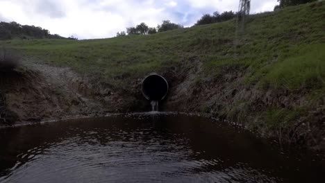 Drone-starts-close-to-a-culvert-then-backs-off-following-the-water-escaping-the-stream