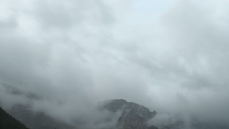 Time-lapse-of-clouds-over-mountain-peak,-dramatic-stormy-sky,-forest-in-foreground,-Ojstrica-peak-in-Kamnisko-Savinjske-Alpe,-Logarska-dolina,-Slovenia,-European-Alps