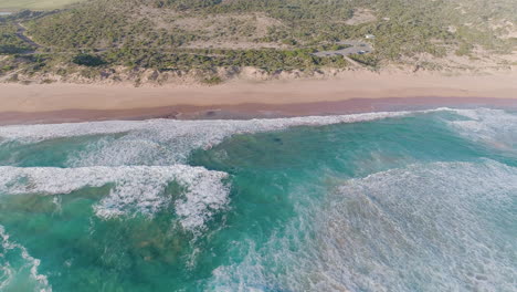 Aerial-shot-of-waves-crashing-into-sandy-coastline-in-South-Australia