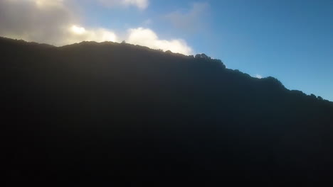 Aerial-time-lapse-of-fog-and-clouds-moving-over-a-mountain-peak