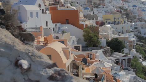 View-of-holiday-homes-and-villas-between-blue-dome-churches-and-church-bells-in-Oia-Santorini