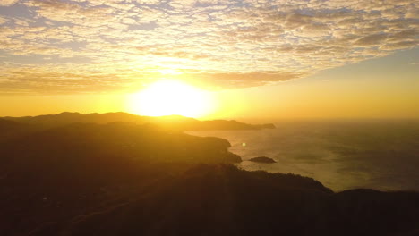 Aerial-view-of-a-bright-yellow-sunrise-over-a-tropical-mountain