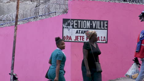 Petion-Ville-sign-with-people-and-cars-passing-in-front-of-the-sign