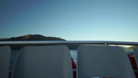 Empty-boat-seats-during-morning-sunrise-cruise-in-Queen-Charlotte-Sound,-New-Zealand-with-mountains-in-background