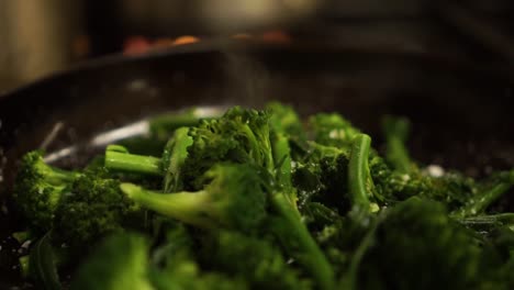 SLOWMO---Close-Up---Sprinkling-salt-on-steamed-fresh-green-broccoli-on-a-black-frying-pan