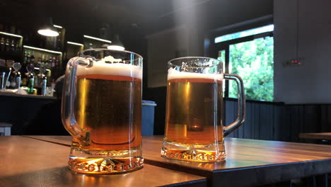 Two-mugs-of-beer-on-table-in-a-bar