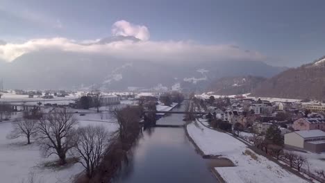 Levantándose-Disparado-Sobre-Un-Canal-Recto-Y-Un-Pueblo-Muy-Pequeño-En-Suiza
