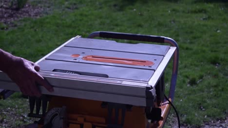 A-close-up-of-a-man-securing-his-portable-table-saw-with-a-safety-guard