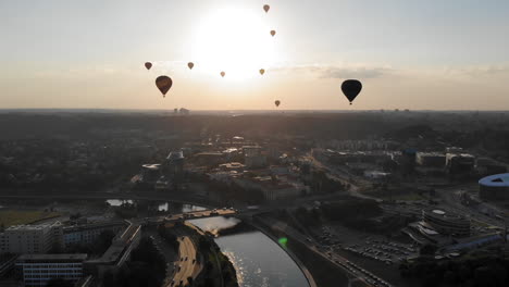 Wegfliegen-Von-Der-Bunten-Packung-Heißluftballons,-Die-über-Der-Stadt-Und-Dem-Fluss-Fliegen