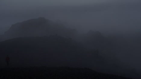 dramatic-iceland-landscape-at-night,-camera-movement,-camera-pan-from-right-to-left-to-reveal-a-person-walking-towards-the-camera