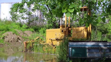 Abandoned-construction-equipment-sits-in-still-water-while-it-rusts-away