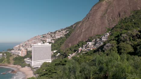 Straight-up-ascending-aerial-shot-from-a-parking-lot-with-palm-trees-and-revealing-the-Two-Brothers-mountain-and-Vidigal-beach-in-Rio-de-Janeiro