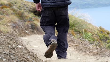 close-up-on-the-feet-of-a-man-hiking-in-Ben-Lomond-Track,-Queenstown,-New-Zealand