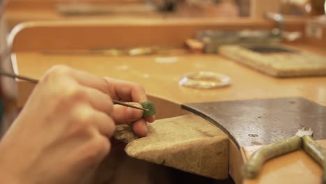 Detail-of-filling-a-small-hole-in-green-stone-from-New-Zealand-in-jewelry-factory---slow-motion