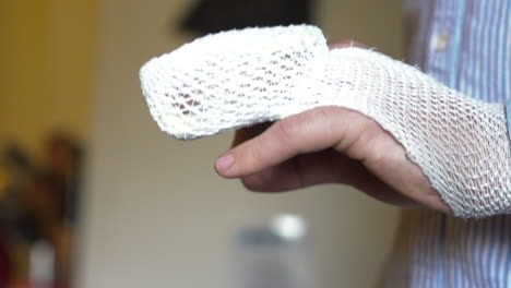 Close-up-side-shot-of-a-broken-finger,-fractured-hand,-with-bandage
