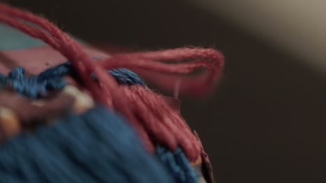 Close-up-shot-of-an-embroidery-needle-being-pulled-through-a-jacket