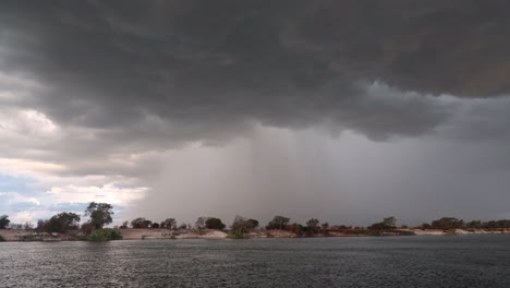 Ein-Sommersturm-Näherte-Sich-Brauen-Mit-Regen-Und-Wind-Im-Südlichen-Zambia,-Von-Einem-Kleinen-Boot-Auf-Dem-Zambezi-Entlang-Der-Namibischen-Grenzseite-Des-Flusses-Aus-Gesehen