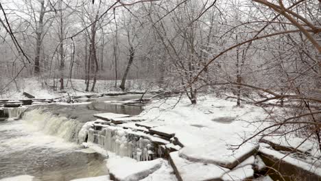 A-revealing-shot-of-a-small-river-waterfall-in-winter