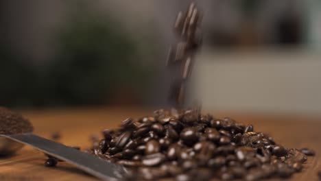 Roasted-coffee-beans-falling-onto-a-wooden-surface