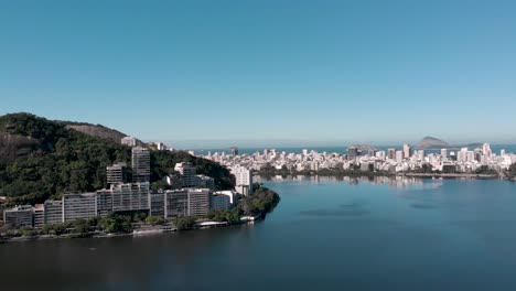 Langsamer-Schwenk-Aus-Der-Luft-Um-Den-Stadtsee-Lagoa-Rodrigo-De-Freitas-In-Rio-De-Janeiro,-Der-Drei-Berge-Enthüllt,-Die-Von-Der-Nachbarschaft-Von-Ipanema-Ausgehen