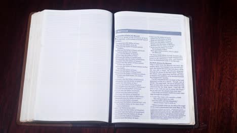 Aufnahme-Von-Oben-Nach-Unten-Einer-Ledergebundenen-Bibel,-Die-Zum-Matthäusbuch-Geöffnet-Wird