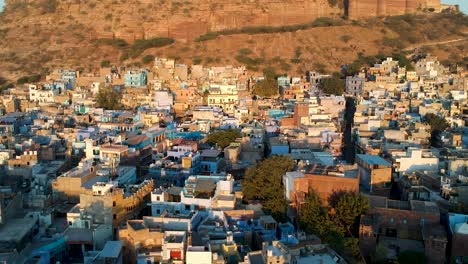 Sunrise-fly-over-of-densely-populated,-Blue-city-of-Jodhpur,-Rajasthan,-India