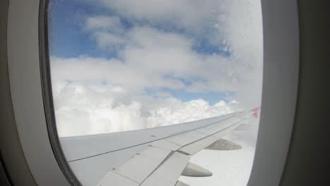 Airplane-flying-over-huge-white-clouds