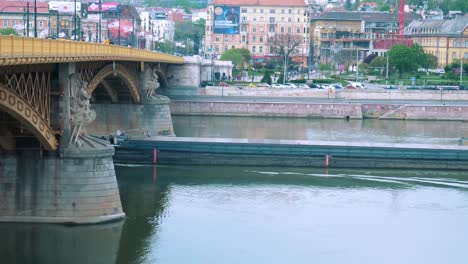 Slow-motion-show-of-Cargo-Ship-passing-under-Margaret-Bridge-in-Danube-river