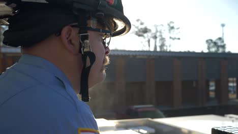 Firefighter-stands-in-early-morning-sunlight-ready-to-respond-to-emergencies-at-a-fire-department